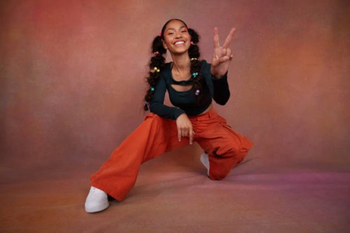 portrait of smiling teenage girl gesturing peace sign against brown background - fashion stock pictures, royalty-free photos & images