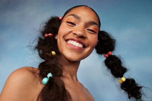 portrait of smiling teenage girl with braided hair against colored background - fashion stock pictures, royalty-free photos & images