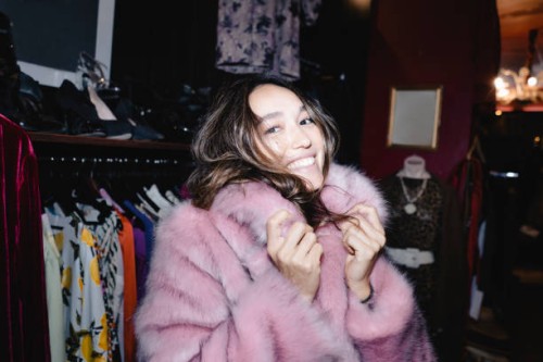 portrait of smiling woman wearing pink fur jacket at thrift store - fashion stock pictures, royalty-free photos & images