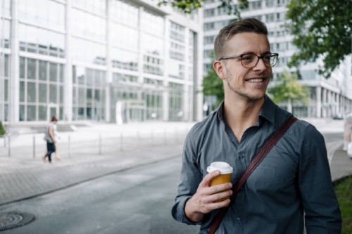 portrait of smiling young businessman with coffee to go - junk food stock pictures, royalty-free photos & images