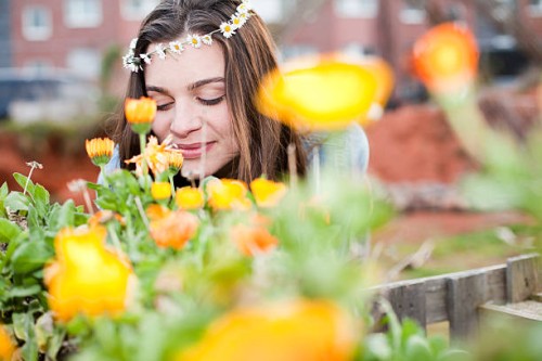 portrait of smiling young woman enjoying flowers - garden decoration stock pictures, royalty-free photos & images