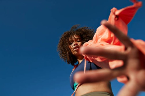 portrait of sportswoman gesturing against clear blue sky - fashion stock pictures, royalty-free photos & images