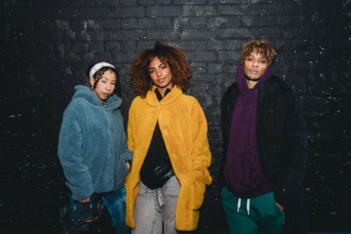 portrait of three hip friends together against a black bricks wall - fashion stock pictures, royalty-free photos & images