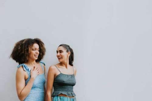 portrait of two beautiful woman against a white wall - fashion stock pictures, royalty-free photos & images
