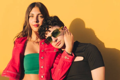 portrait of two young stylish boys on an orange background - fashion stock pictures, royalty-free photos & images