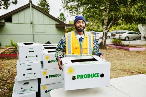 portrait of volunteer at community center giving away csa boxes - food stock pictures, royalty-free photos & images