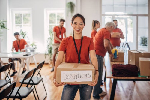 portrait of volunteer holding donation box with goods for people in need - food stock pictures, royalty-free photos & images
