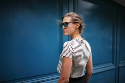 portrait of woman against blue wall - fashion stock pictures, royalty-free photos & images