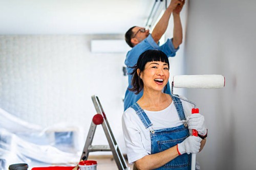 portrait of woman holding paint roller during home renovation - home decoration stock pictures, royalty-free photos & images