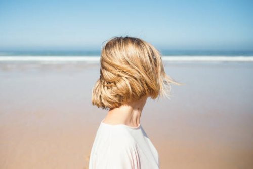 portrait of woman looking at the ocean beach. - hairstyle stock pictures, royalty-free photos & images