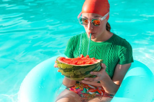 portrait of woman with floating tire and watermelon in swimming pool - fashion stock pictures, royalty-free photos & images