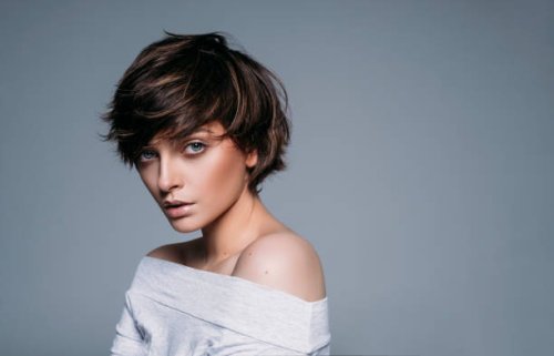 portrait of young female model with short hair on blue background - hairstyle stock pictures, royalty-free photos & images