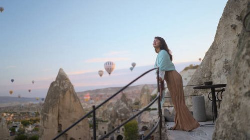 portrait of young female tourist watching hot air ballons from balcony in cappadocia during her travel - travel stock pictures, royalty-free photos & images