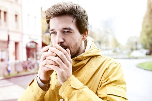 portrait of young man holding coffee cup - junk food stock pictures, royalty-free photos & images