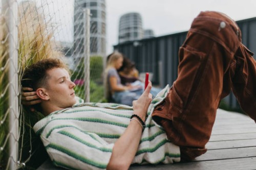 portrait of young stylish generation z boy browsing on smartphone. - fashion stock pictures, royalty-free photos & images