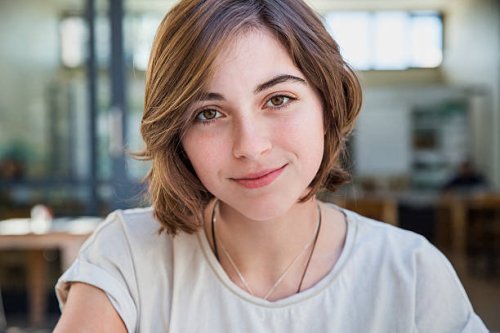 portrait of young woman in cafe, smiling - hairstyle stock-fotos und bilder