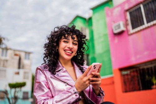 portrait of young woman using mobile phone outdoors - fashion stock pictures, royalty-free photos & images