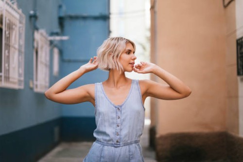 portrait of young woman wearing light blue overall in the city - fashion stock pictures, royalty-free photos & images