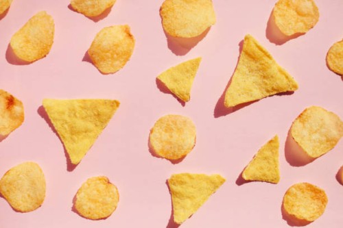 potato chips pattern over pink background, hard light with shadows. unhealthy junk food concept. - junk food stock pictures, royalty-free photos & images
