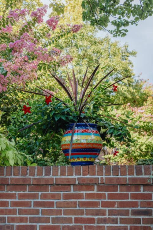 potted plant on top of garden wall - garden decoration stock pictures, royalty-free photos & images