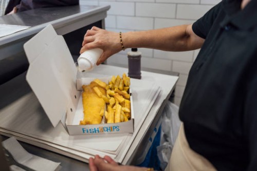 pouring salt on fish and chips - junk food stock pictures, royalty-free photos & images