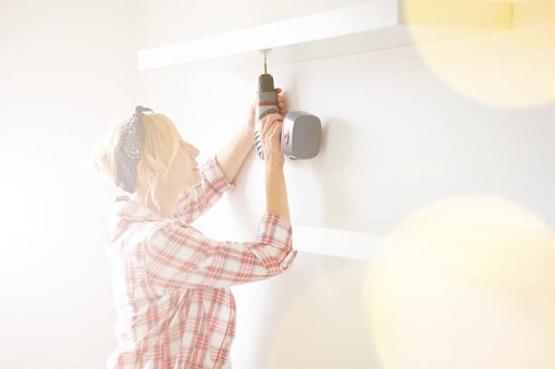 pregnant woman installing a shelf - home decoration stock pictures, royalty-free photos & images