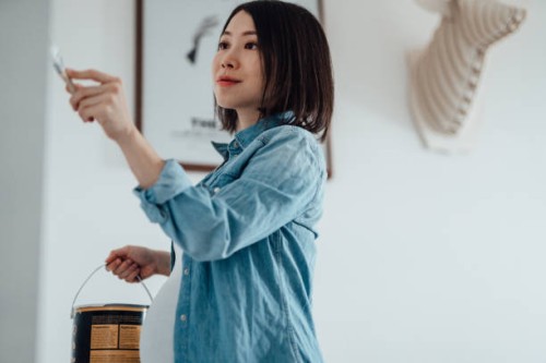 pregnant woman painting nursery room - home decoration stock pictures, royalty-free photos & images