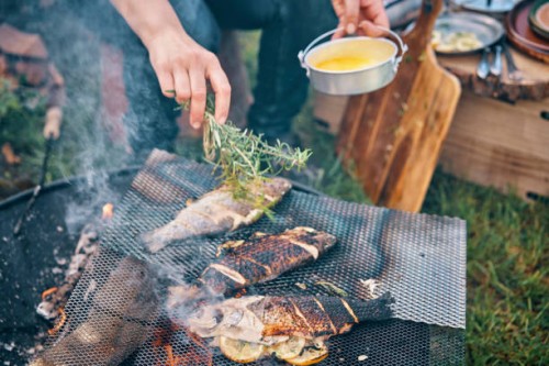 preparing fish for cooking over open campfire - food stock pictures, royalty-free photos & images