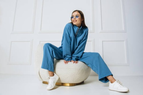 pretty fashionable young brunette woman in colorful clothes having fun sitting in armchair smiling isolated on white background in studio. happy fashion model indoors - fashion stock pictures, royalty-free photos & images