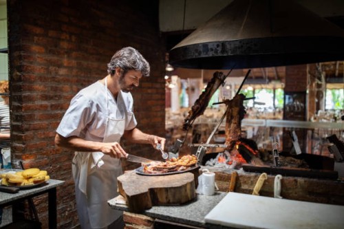 professional chef cooking meat in a restaurant kitchen - food stockfoto's en -beelden