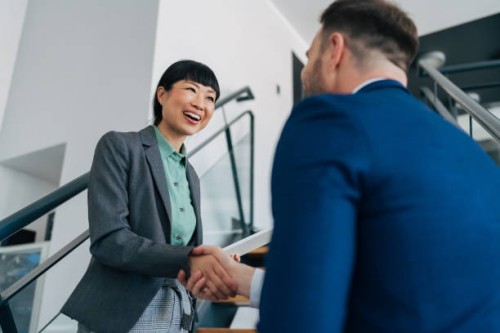 professionals meeting and shaking hands on stairs. - fashion stock pictures, royalty-free photos & images
