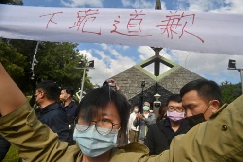 Protester is take away by security staffs during a ceremony marking the 76th anniversary of "228 incident" at the 228 Peace Park in Taipei on...