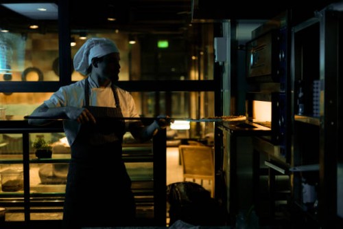 putting pizza into the baking oven! - junk food stock pictures, royalty-free photos & images