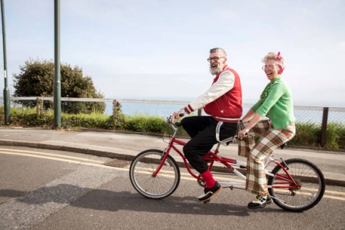 quirky couple sightseeing on tandem bicycle, bournemouth, england - fashion stock pictures, royalty-free photos & images