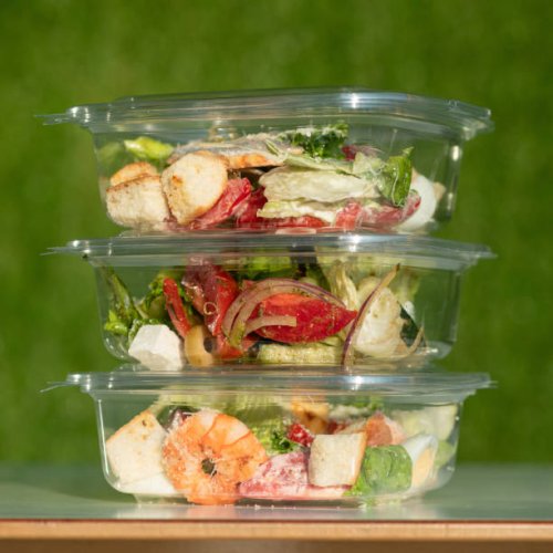 ready-to-eat food, three transparent plastic containers with salads on green background. tower from disposable tableware with healthy eating. side view - junk food stock pictures, royalty-free photos & images