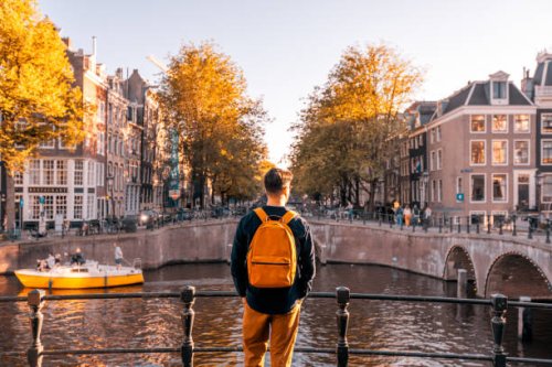 rear view of a man looking at amsterdam canal on a sunny day, netherlands - travel stock pictures, royalty-free photos & images