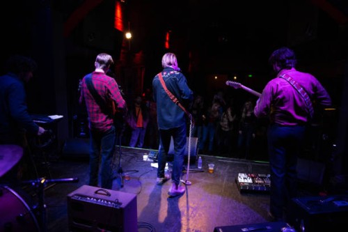 rear view of band performing for audience at small venue - concert stock pictures, royalty-free photos & images