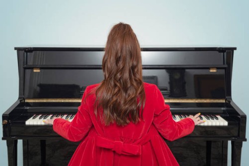 rear view of woman playing piano - concert stock pictures, royalty-free photos & images