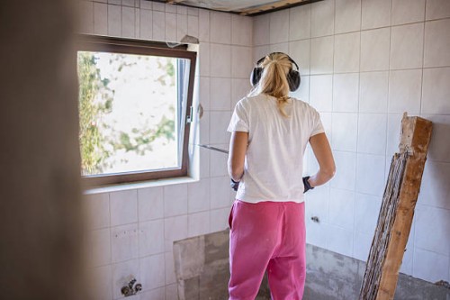 rear view of woman renovating house holding work tool - home decoration stock pictures, royalty-free photos & images