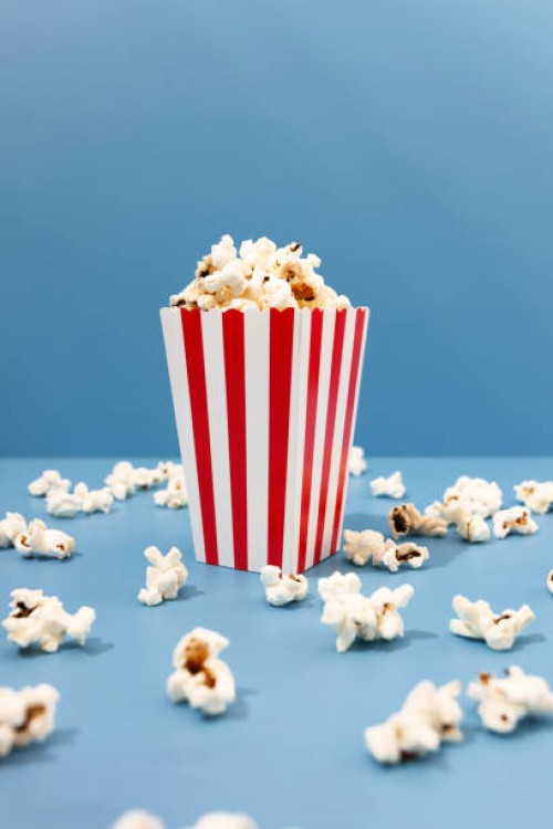 red paper striped bucket with popcorn on the blue background - junk food stock pictures, royalty-free photos & images