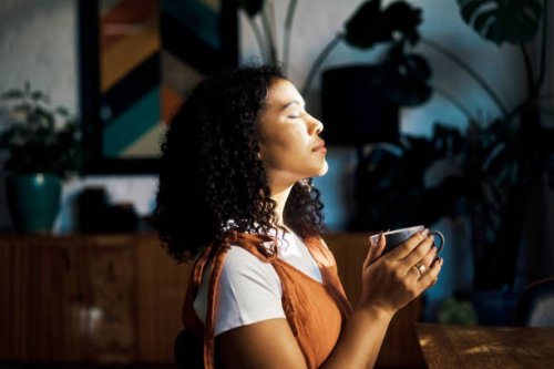 relax, peace and coffee with a woman drinking a drink of caffeine and meditating in her home with her eyes closed. mental health, wellness and zen with a young female enjoying calm, quiet tranquility - coffee stock pictures, 