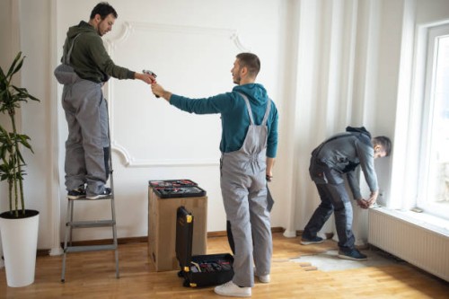 repairman team working together in client's house - home decoration stock pictures, royalty-free photos & images