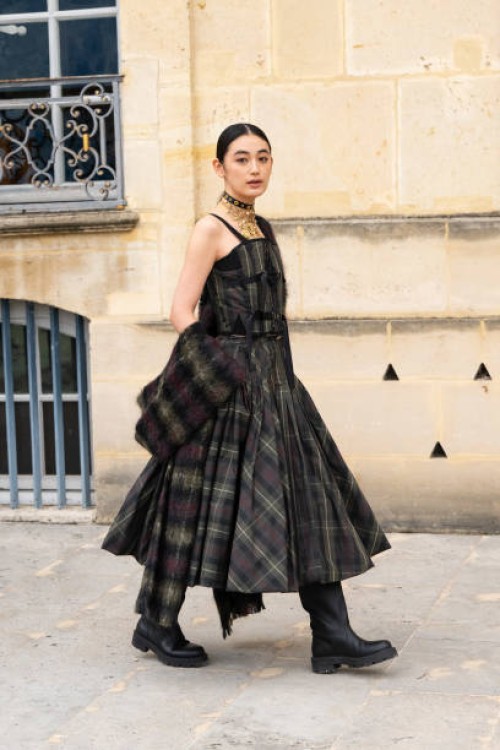 Rikako Yagi wears a Dior plaid dress and black boots outside the Dior show during Womenswear Spring/Summer 2025 as part of Paris Fashion Week on...