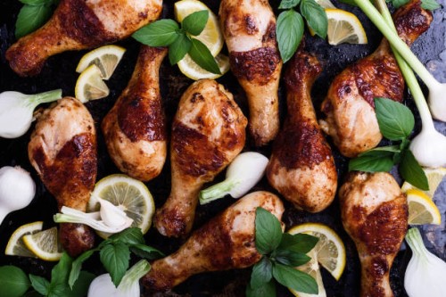 roasted chicken legs with vegetables and herbs on baking tray - junk food stock-fotos und bilder