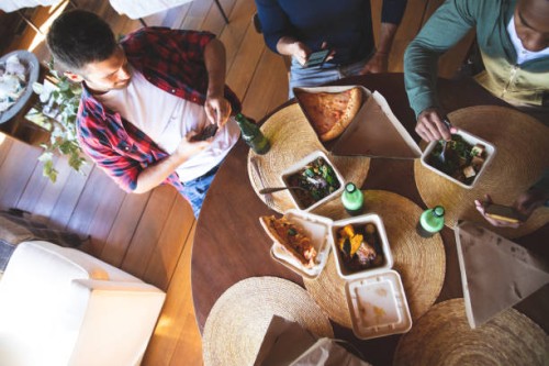 roommates friends ordering and eating delivery food pizza e salads - junk food stock pictures, royalty-free photos & images