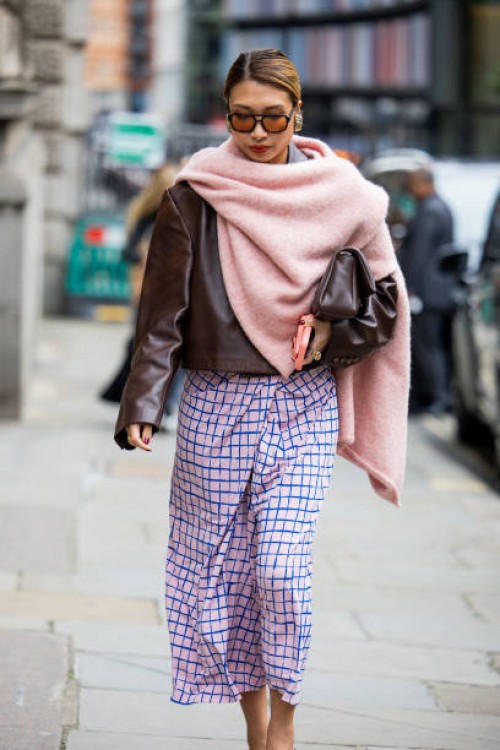 Rosana Lai wears pink scarf, checkered pink skirt, brown leather jacket outside Simone Rocha during London Fashion Week September 2024 on September...