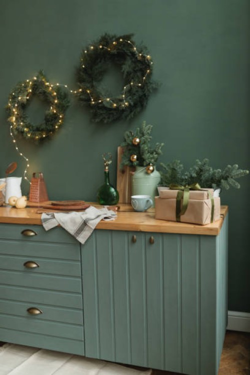 rustic kitchen decorated for christmas with fir wreaths, fir decorations, christmas baubles and illuminated fairy lights - home decoration stock pictures, royalty-free photos & images