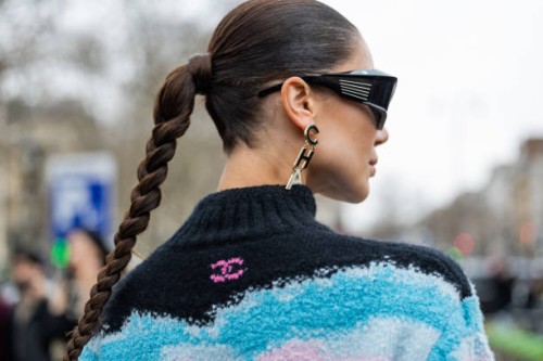 Sabina Jakubowicz wears black sunglasses, earrings with Chanel letters, turtleneck with 5 print outside Chanel during Paris Fashion Week - Womenswear...