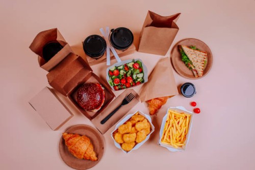 salad and fast foods with coffee cups against beige background - junk food stock pictures, royalty-free photos & images