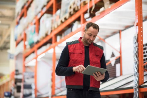 salesman using digital tablet while standing by shelf in hardware store - home decoration stock pictures, royalty-free photos & images